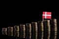 Danish flag with lot of coins isolated on black Royalty Free Stock Photo