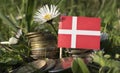 Danish flag with stack of money coins with grass Royalty Free Stock Photo