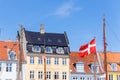 Danish flag waves background Nyhavn colorful house buildings in canal harbor Copenhagen sightseeing tourist travel Royalty Free Stock Photo