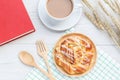 Danish pastries, coffee and note book on white wooden table