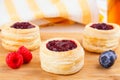 Danish pastry cake with cranberry jam and fresh blueberry and raspberry on the table. Sunny breakfast Royalty Free Stock Photo