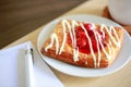 Danish pastry with a cup of hot tea and a pen and small notebook on wood table in morning time Royalty Free Stock Photo