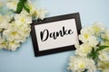 Danke text with flowers decoration on light blue background Royalty Free Stock Photo