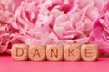 Danke wooden blocks with pink flowers background Royalty Free Stock Photo