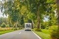 Camper with a bike carrier and bicycles mounted on it on a country road. T