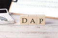 DAP word on a wooden block with clipboard and calcuator Royalty Free Stock Photo