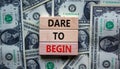 Dare to begin symbol. Wooden blocks with words `Dare to begin`. Beautiful background from dollar bills. Business, dare to begin