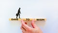 Dare to begin symbol. Wooden blocks with words `Dare to begin`. Beautiful white background, businessman hand, businessman icon.