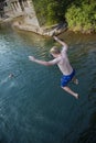 Daring young boy jumping off a bridge into the river. Being adventurous and brave, diving right into the water Royalty Free Stock Photo
