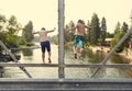 Daring young boys jumping off a bridge into the river. View from behind.