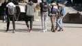 Darjeeling, India - May 2018: Group of smiling friends walking on road at day time. Back view. Cropped image. People having fun