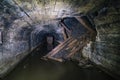 Dark abandoned coal mine with rusty remnants of equipment