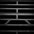 Dark, abstract pattern featuring an iron grate with rectangular and arched cutouts. The Royalty Free Stock Photo