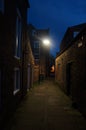 Dark alleyway with street lamp & twilight sky