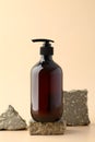 Dark amber glass pump bottle on stone pedestal. Soap gel bottle branding, natural organic spa shampoo container design Royalty Free Stock Photo