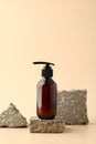 Dark amber glass pump bottle on stone podium. Natural beauty product design, cosmetics branding