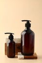 Dark amber glass shampoo and hair gel bottles on wooden and stone podium. Natural beauty product design, cosmetics branding