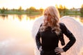 dark angel. blonde sexy woman in black leather clothes with white angels wings Royalty Free Stock Photo