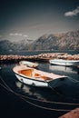 Dark atmospheric picture of nature. Montenegro mountains, boats in the water. Weather before rain, stylish postcard