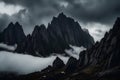 Dark atmospheric surreal landscape with dark rocky mountain top in low clouds in gray cloudy sky. Royalty Free Stock Photo