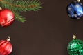 Dark background with Christmas fir branch, red wavy, blue and green ball Royalty Free Stock Photo