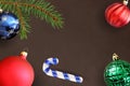 Dark background with Christmas fir branch, stick, blue, green ribbed and red wavy ball Royalty Free Stock Photo