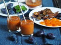 Dark background with glasses of orange juice on a blue napkin.Juice or smoothie made from natural plum with ingredients for