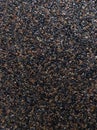 A dark background of many small stones in close-up. Abrasive surface. Royalty Free Stock Photo