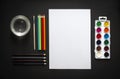 On dark background paint sheet brush pencils colored jar with water horizontal top view flat lay background knolling