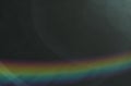 Dark background with a rainbow. Part of the rainbow on a dark abstract background