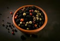 Dark background showing a stone mortar up close and black peppercorns with with space for text