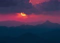 Dark background with sun and clouds over far mountains Royalty Free Stock Photo