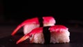 On a dark background on a tray, cooked or purchased sushi Nigiri taste Chinese chopsticks. Concept of: Nigiri, Sushi of the Day,