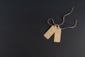 on a dark background, two blank trade labels, price tags from kraft paper with rope. Royalty Free Stock Photo