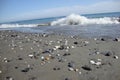 Dark beach with stones and wave in backgroun