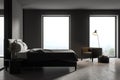 Dark bedroom interior with bed and armchair near window Royalty Free Stock Photo