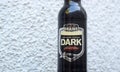 Dark beer bottle from Brains brewery on light textured background.