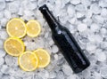 Dark beer bottle with lemon slices in the ice Royalty Free Stock Photo