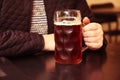 Dark beer. Defocus mug of dark beer. Closeup of two hands clinking beer stein glasses. People, woman or man drinking Royalty Free Stock Photo