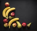 On a dark black background red yellow apples pears bananas frame view from above flat lay horizontal Royalty Free Stock Photo