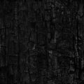 Dark black background of rough burnt wood, soot, and ash. Seamless tile