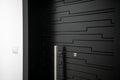 A dark black color metallic door in the interior of a flat building with modern architecture