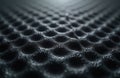 Dark black fabric surface with a repeating hexagonal cell pattern. The textile has a smooth, textured look with a subtle wave Royalty Free Stock Photo