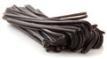Dark black licorice candy bundles on white surface.