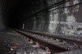 Dark black shaded tunnel in an underground tunnel in a cavern of a railway along the tracks of a train towards the station Royalty Free Stock Photo