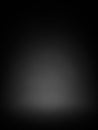 A dark, almost black studio background with a subtle gradient and a soft, diffused spotlight in the center, creating a moody and Royalty Free Stock Photo