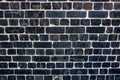 Dark, black Weathered brick wall made from reclaimed bricks. Black brick wall