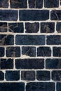 Dark, black Weathered brick wall made from reclaimed bricks. Black brick wall