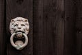 Dark black wooden background with lion shaped door knocker and c Royalty Free Stock Photo