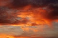 Dark blood red sky background. Dramatic heavy clouds with the hint of the sun at sunset. Many orange tones and patterns of clouds Royalty Free Stock Photo